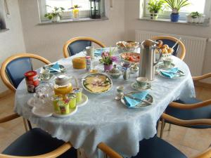 ブリーデルにあるWeingut u. Gästehaus Mentenの白いテーブルクロスと食べ物