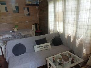 a living room with a couch with a tray of food at A LO DE MARY cabañas Isla Tigre in Tigre +17 photos