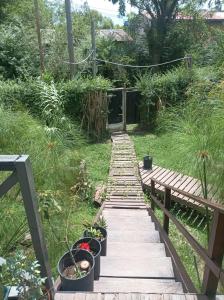 a wooden walkway in a garden with potted plants at A LO DE MARY cabañas hospedaje in Tigre