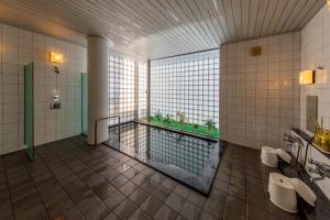 a bathroom with three urinals and a swimming pool at Sunhills Sarai in Shintotsukawa