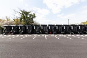 a row of black containers in a parking lot at HOTEL R9 The Yard Kanzaki in Kanzaki