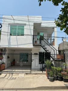 ein weißes Haus mit einem schmiedeeisernen Tor in der Unterkunft Deusades Apartamentos in Cartagena de Indias