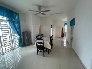 a dining room with a table and chairs and a ceiling fan at MDRS Seroja 7 in Kuala Ketil
