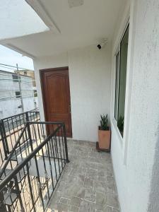 einen Balkon eines Hauses mit Tür und Pflanze in der Unterkunft Deusades Apartamentos in Cartagena de Indias