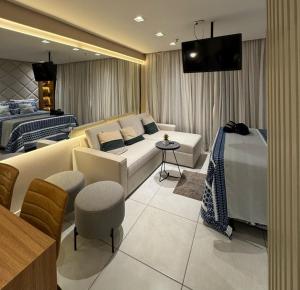 a living room with a couch and a bed at Flat Presidencial Vivence Hotel in Palmas