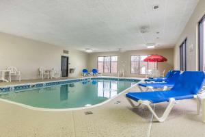 a large swimming pool with blue chairs and a red umbrella at Comfort Inn Alton near I-255 in Alton