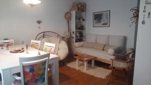 Nel's Casa Hostel A 15 minutos de Aeropuerto Ezeiza في مونتي غراندي: غرفة معيشة بها أريكة وطاولة