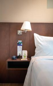 a bedroom with a bed and a lamp on a night stand at Swiss Hotel Apartment in Kuala Belait