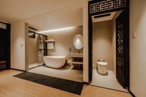 a bathroom with a toilet and a tub and a sink at Dali Wenshuo Ancient City Center Private Courtyard Hotel in Dali Ancient Town +189 photos