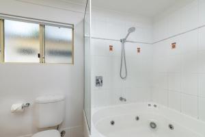 ein weißes Badezimmer mit Badewanne und Toilette in der Unterkunft Seascape Holidays at Plaza Resort in Port Douglas