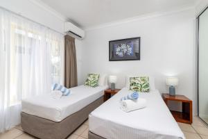 ein Hotelzimmer mit zwei Betten und einem Fenster in der Unterkunft Seascape Holidays at Plaza Resort in Port Douglas + 19 Fotos
