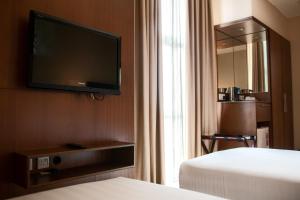 a hotel room with two beds and a flat screen tv at Swiss Hotel Apartment in Kuala Belait
