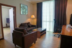 a living room with a couch and a table at Swiss Hotel Apartment in Kuala Belait