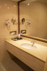 a bathroom with a sink and a mirror at Swiss Hotel Apartment in Kuala Belait