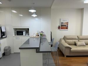 a kitchen and living room with a table and a couch at Haeundae Beach Stay Hotel in Busan