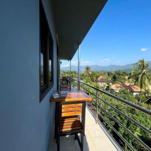 a balcony with a wooden table and a view at VangVieng Smile guesthouse in Vang Vieng +37 photos