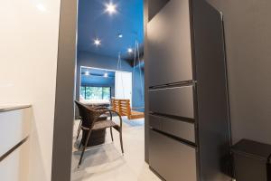 a kitchen with a refrigerator and a dining room at Tida Sesoko in Motobu