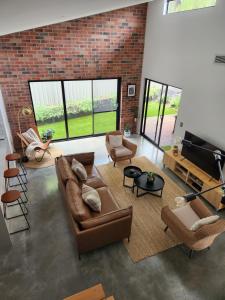 a living room with leather furniture and a brick wall at Mojo's Lodge in Margaret River Town