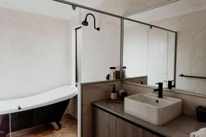 a bathroom with a tub and a sink and a bath tub at Mojo's Lodge in Margaret River Town +19 photos