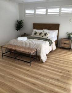 a bedroom with a large bed and a wooden floor at Mojo's Lodge in Margaret River Town