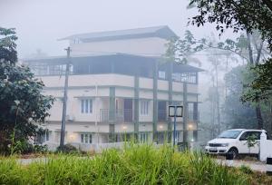 WayanadRhythm Residency Wayanad的一辆白色汽车停在一栋建筑物前