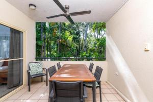 ein Esszimmer mit Tisch und Stühlen und einem Deckenventilator in der Unterkunft Seascape Holidays at Plaza Resort in Port Douglas