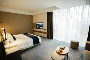 Ένα ή περισσότερα κρεβάτια σε δωμάτιο στο Golden Tulip Jinzhou Central Street