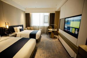Ένα ή περισσότερα κρεβάτια σε δωμάτιο στο Golden Tulip Jinzhou Central Street