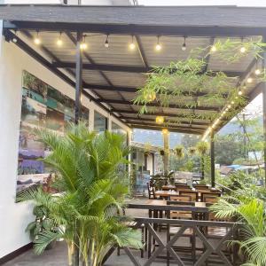 ein Restaurant mit Holztischen, Bänken und Pflanzen in der Unterkunft VangVieng Smile guesthouse in Vang Vieng + 30 Fotos