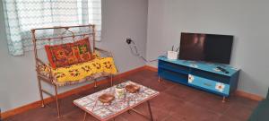 a living room with a bed and a tv and a table at La Casita en Caldera in Caldera