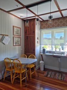 a kitchen with a table and chairs and a sink at Waitawheta Cottage in Waihi