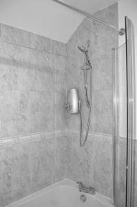 a shower in a bathroom with a sink at East Croydon in South Norwood