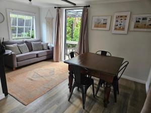 a living room with a table and chairs and a couch at The Loft Guesthouse NZ in Whangarei