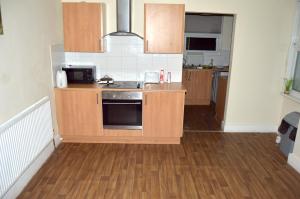 a kitchen with wooden cabinets and a stove top oven at West Croydon in Croydon