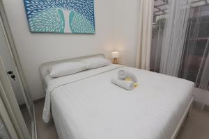 a bedroom with a white bed with a towel on it at Rivera Villa Seminyak in Seminyak +62 photos