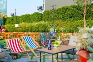 a patio with chairs and a table and a table and chairs at The Quartier Hotel Phromphong - Thonglor in Bangkok