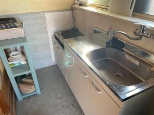 a small kitchen with a sink and a shelf at 淡路屋-Awajiya vacation home-ドッグラン付き別荘 BBQ PET OK in Awaji +27 photos