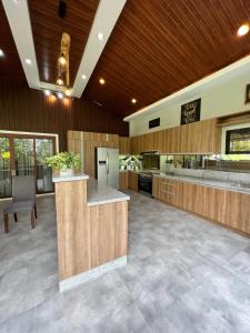 una grande cucina con pareti in legno e soffitto in legno di Di Bella Cabin Private Resort a Pampang