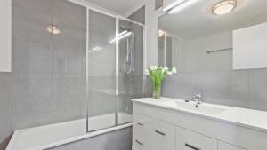 a white bathroom with a sink and a shower at Lawlers 30 in Mount Hotham