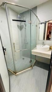 a glass shower in a bathroom with a sink at Era Apartment Chua Ha in Hanoi