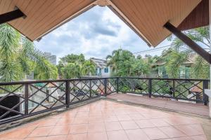 a balcony with a wooden railing and palm trees at Thai Me22 3B near Hollywood in Pattaya Central