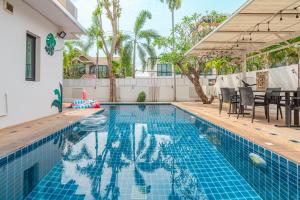 a swimming pool with a table and chairs next to a house at Thai Me22 3B near Hollywood in Pattaya Central