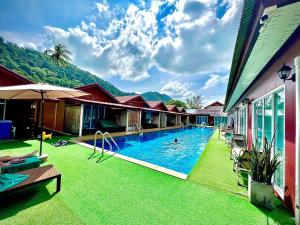 a resort swimming pool with a mountain in the background at Lanta For Rest Boutique in Ko Lanta