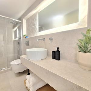 a white bathroom with a sink and a toilet at Philokali in Sitia