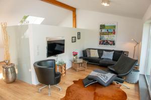 a living room with a couch and a tv at Ferienhaus am Bellachini in Sankt Martin