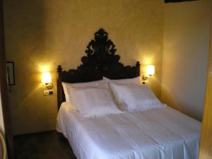 1 dormitorio con 1 cama grande con sábanas y almohadas blancas en Ca l'Estruch, en Vallclara