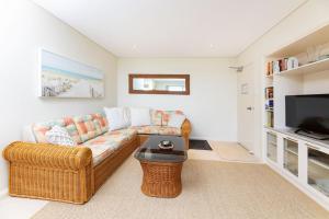 a living room with a couch and a television at Tuncurry Tides in Tuncurry