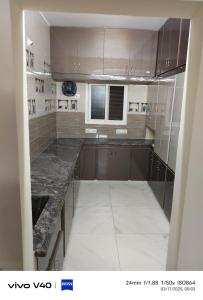 a kitchen with brown cabinets and a marble counter top at AJ srinivasa HOMESTAY in Tirupati