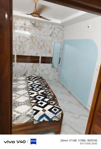 a bed in a room with a wall at AJ srinivasa HOMESTAY in Tirupati +5 photos