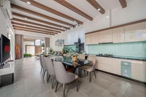 a kitchen with a glass dining table and chairs at Thao Villas Da nang in Da Nang